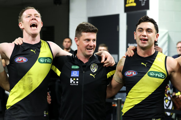 Tigers interim head coach Andrew McQualter and Tim Taranto of the Tigers sing the team song after beating GWS 