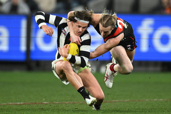 Jack Ginnivan of the Magpies is tackled by Mason Redman of the Bombers during the round 24 AFL match.