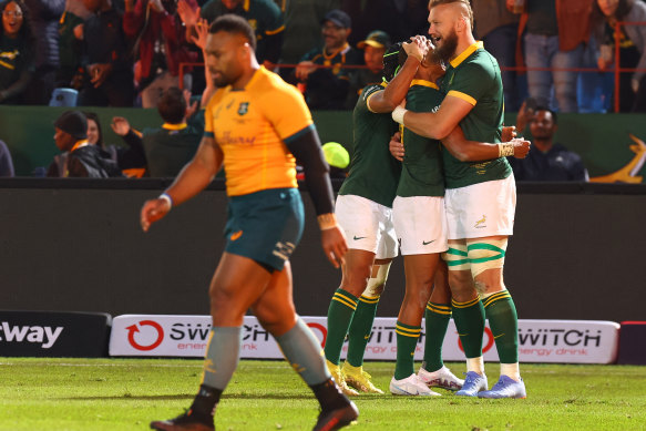 Samu Kerevi walks off as South Africa celebrate after their victory.