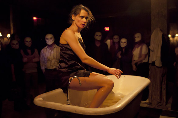 Audience members wear masks as they wander through the action of New York’s Sleep No More.