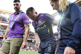 Cameron Munster limps from the Suncorp Stadium turf.