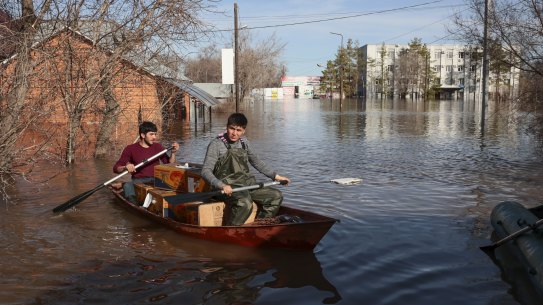 Two men ride a boat delivering food in Orenburg, Russia. Russian officials are scrambling to help homeowners displaced by the rising waters of the Ural River. 