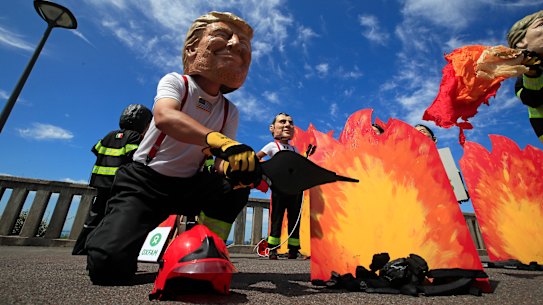 A man wearing a mask President Donald Trump, front left, is joined by other 'world leaders' during a protest ahead of the G-7 summit in Biarritz, France.