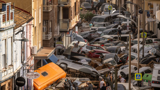 Cars are piled in the street with other debris after flash floods hit the region in the Sedaví area of Valencia, Spain.