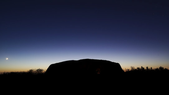 The Saturday sun rises over Uluru, the first morning after the climb was permanently closed.