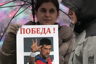 A woman holds up a picture of Novak Djokovic during a protest in Belgrade, Serbia, over the tennis player’s detention.