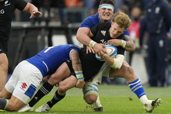 New Zealand’s Damian McKenzie, is tackled by Italy’s Marco Riccioni.