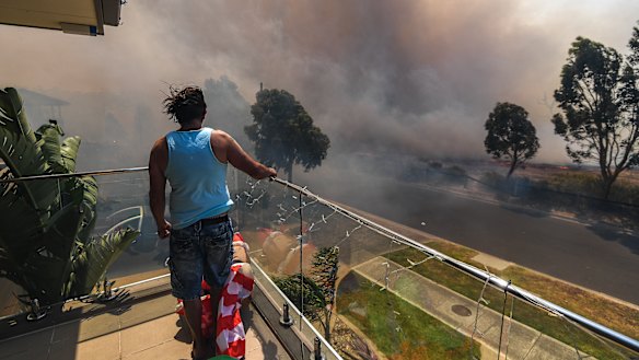Ange Vlahopoulos watches as the fire approaches his home at 4pm today.