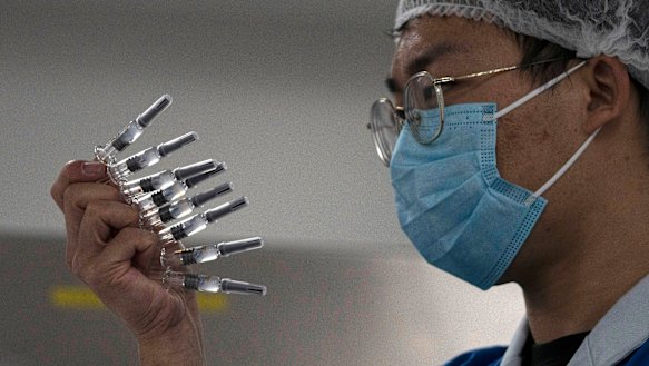 An employee inspects syringes of the SARS CoV-2 at Sinovac.