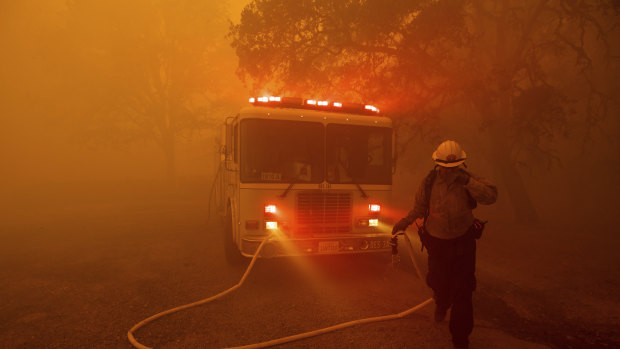 A firefighter rushes to save a home as the River Fire tears through Lakeport, California, on Tuesday.
