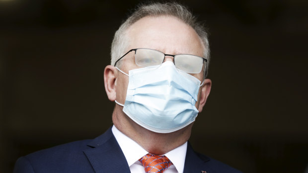 Prime Minister Scott Morrison, seen here with fogged glasses from wearing a mask, has flagged more funding will come for aged care.
