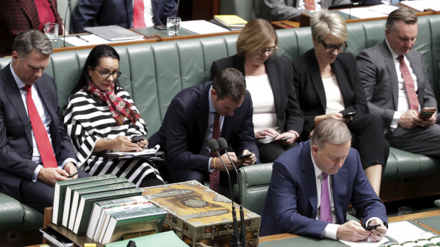 Top Labor frontbenchers on their mobile phones during question time on Monday.