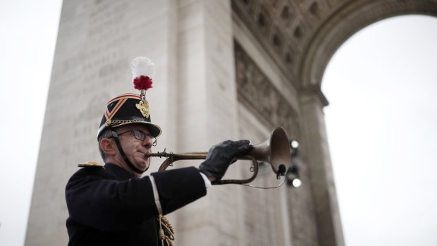A French Republican Guard blows a bugle that signalled the Armistice in 1918 at the Arc de Triomphe on November 11.