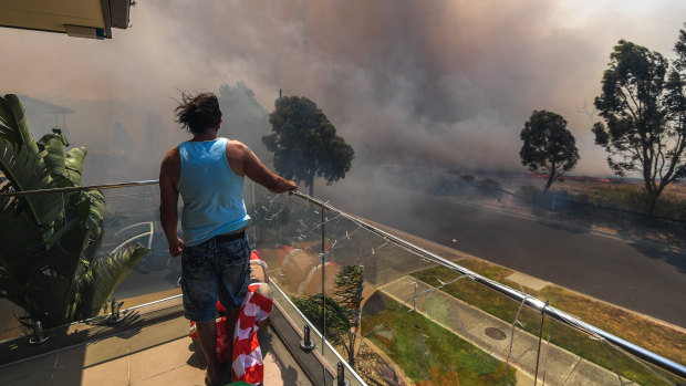 Ange Vlahopoulos watches as the fire approaches his home at 4pm today.