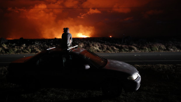 Brittany Kimball watches as lava erupts from a fissure near Pahoa, Hawaii, on Saturday.