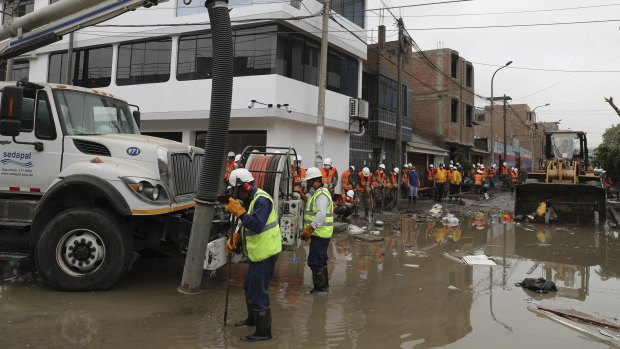 City workers try to drain a street filled with sewage water on Wednesday.