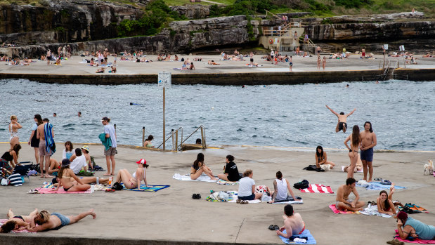 People enjoying the warm day at Clovelly on Monday. The NSW government launched its COVID-19 summer plan on Monday.