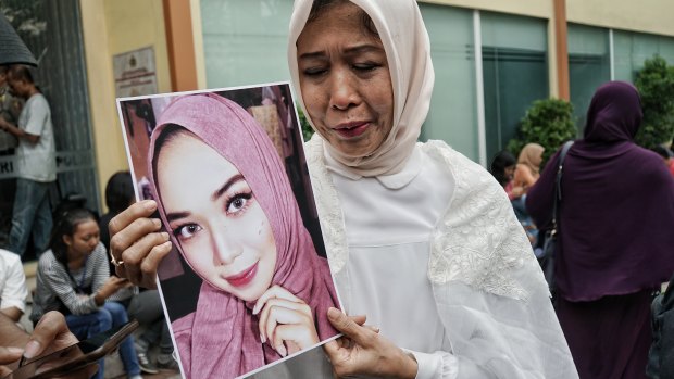 Mrs Nuke (who gave only one name) holds a picture of her daughter, Puspita Eka Putri, who was aboard the crashed Lion Air passenger flight JT610.