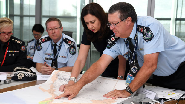 Queensland Premier Annastacia Palaszczuk (centre) is briefed by Police Commissioner Ian Stewart (right) on the floods situation in the state's north at the State Emergency Complex in Brisbane.