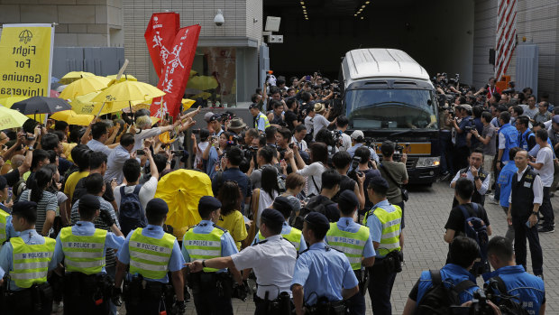 Supporters gather as photographers scramble around a prison van carrying Occupy Central leaders Chan Kin-man, Benny Tai, Raphael Wong and Shiu Ka-chun at a court in Hong Kong.