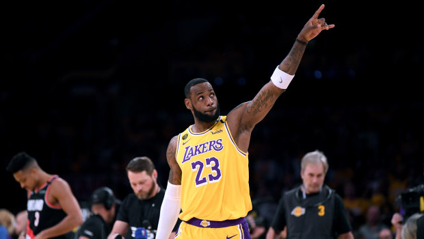 LeBron James #23 of the Los Angeles Lakers points at the two retired jerseys in the rafters to honour Kobe Bryant before the game against the Portland Trail Blazers,