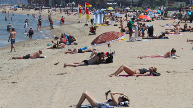 Beachgoers enjoy the sunshine at St Kilda beach at the end of December. 