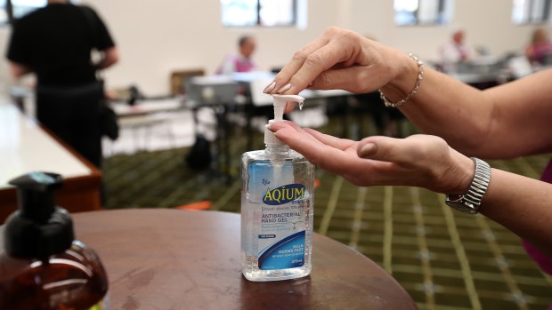 An election official uses sanitiser at the Brisbane City Hall polling booth.