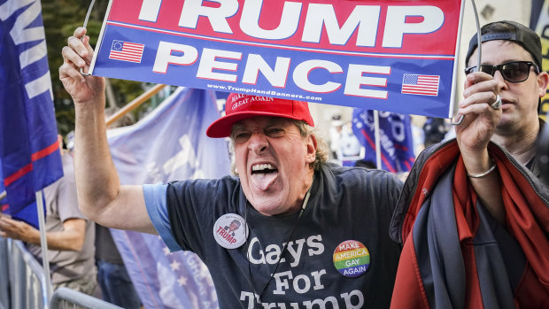 A Trump supporter shouts at crowds celebrating Biden's win.