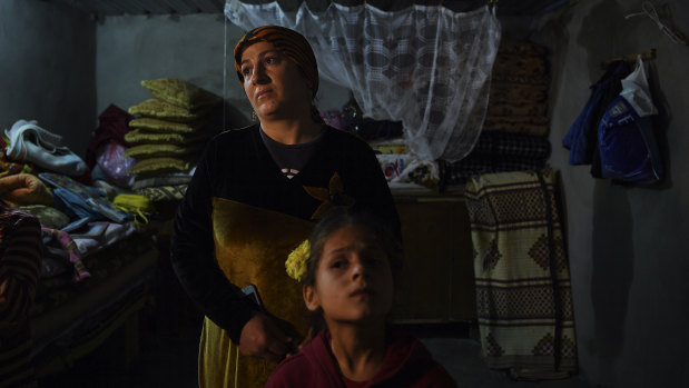 Sehla (left) complains that the roof of her hut leaks as she plaits her daughters hair in Basirma refugee camp, Iraq.