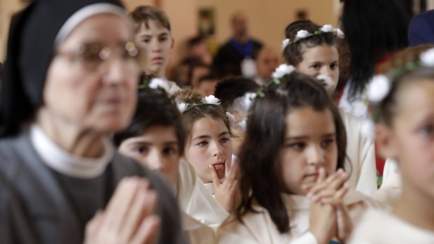 Children wait in the pews for their turn to get the Holy Communion at mass in Bulgaria. 