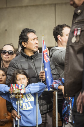 Spectators show their respects during the ANZAC Day march in Melbourne.