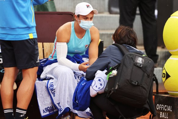 Ash Barty speaks to a trainer before retiring hurt in Rome.