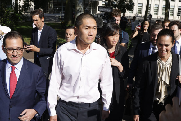L'avocat Seth DuCharme, à gauche, marche avec Linda Sun, au centre à droite, et son mari, Christopher Hu, alors qu'ils quittent le tribunal fédéral de Brooklyn après leur mise en accusation.