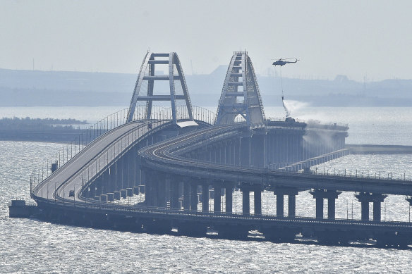 A helicopter drops water to stop fire on Crimean Bridge connecting Russian mainland and Crimean Peninsula over the Kerch Strait, in Kerch, last year.