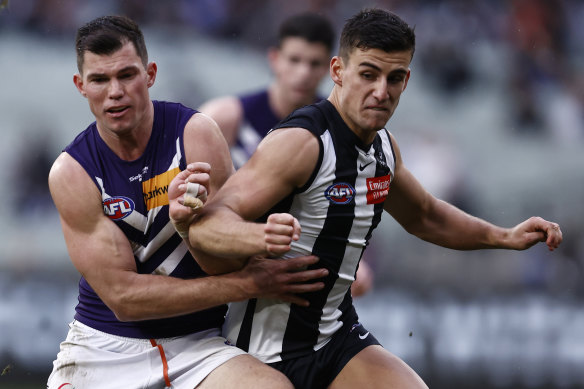 Fremantle’s Jaeger O’Meara tries to bustle Nick Daicos off the ball.