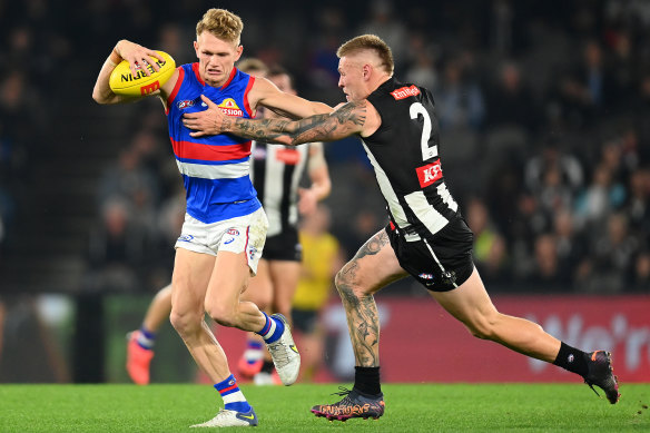 Adam Treloar fends off Jordan De Goey.