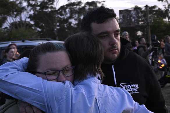Parents Jasmine Beck and Kane McGregor are consoled by well-wishers at a vigil near Geelong.
