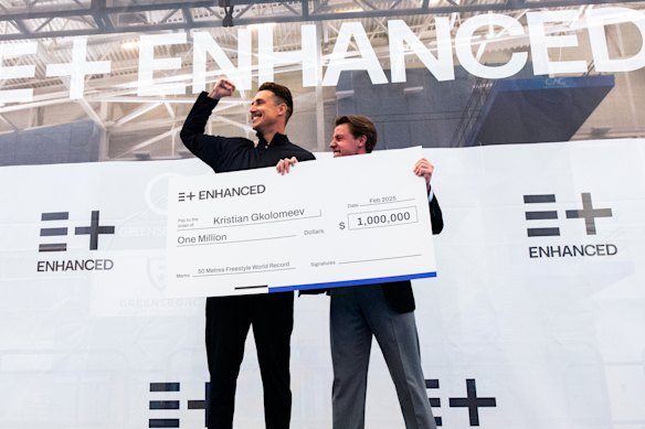 Swimmer Kirstian Gkolomeev picks up his cheque for $US1 million after breaking the men’s 50m freestyle world record as part of an Enhanced Games documentary.