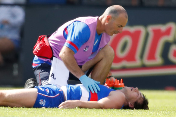 Liam Picken is treated as he lies on the ground after a head knock against Hawthorn in 2018.