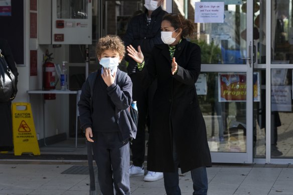 Isabel Batson collects her son from St Charles’ Primary School in Waverley after a child tested positive to COVID-19 on Tuesday. 