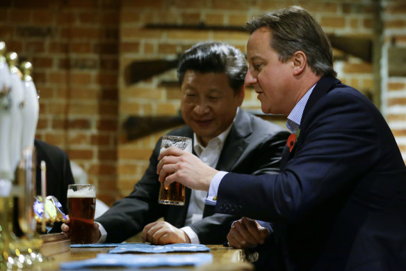 Then-PM David Cameron, right, drinks a pint of beer with Chinese President Xi Jinping, at The Plough pub in Casden, England, in 2015.