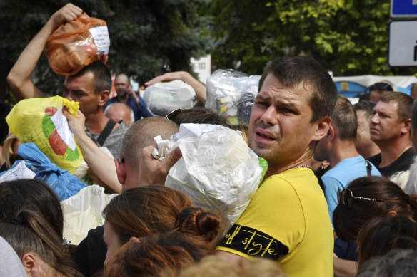 Local residents, many of whom fled the war, gather to hand out donated items such as medicines, clothes, and personal belongings to their relatives on the territories occupied by Russia, in Zaporizhzhia.