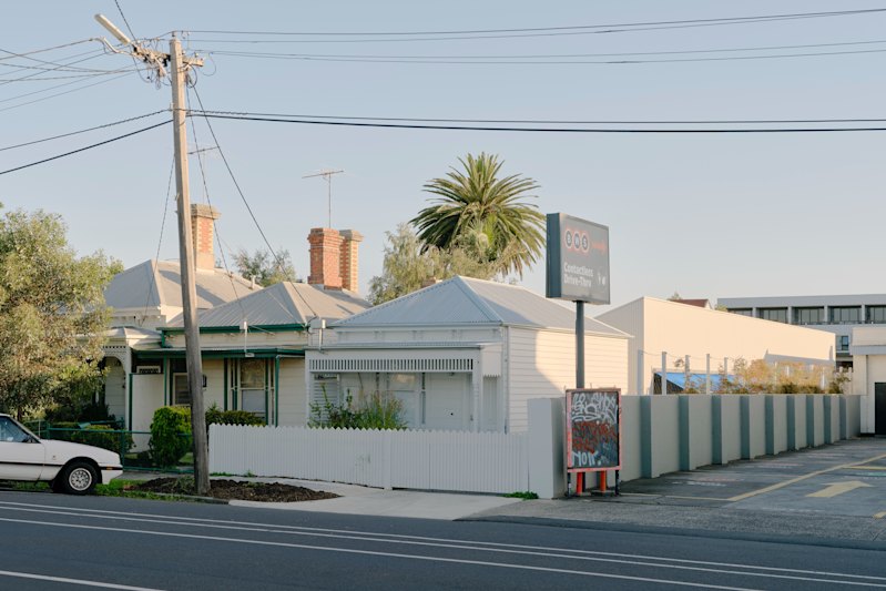 The new single-storey house is next to a major road and butts up to a bottle shop.