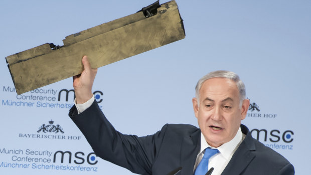 Israeli Prime Minister Benjamin Netanyahu holds part of a downed drone during his speech at the Munich Security Conference.