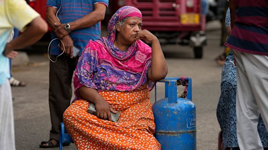 A Sri Lankan woman sits in protest outside a police station demanding cooking oil. 