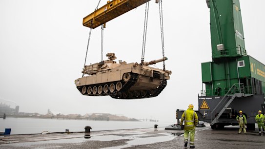 An M1A2 Abram tank is raised over the pier at the Port of Vlissingen, Netherlands, to be lowered onto a low-barge ship for transportation to another location within Europe in 2019.