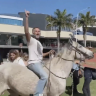 Protesters, including a horseback-riding Michael Corrigan, along the NSW-Queensland border in Coolangatta last Sunday.