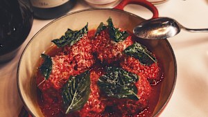 Mario’s meatballs from Carbone, topped with freshly grated Parmigiano-Reggiano, olive oil and a fried basil leaf.