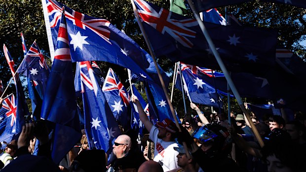 Protesters wave flags as they march against immigration.