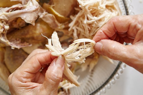 Your hands are the best tool to shred poached chicken.